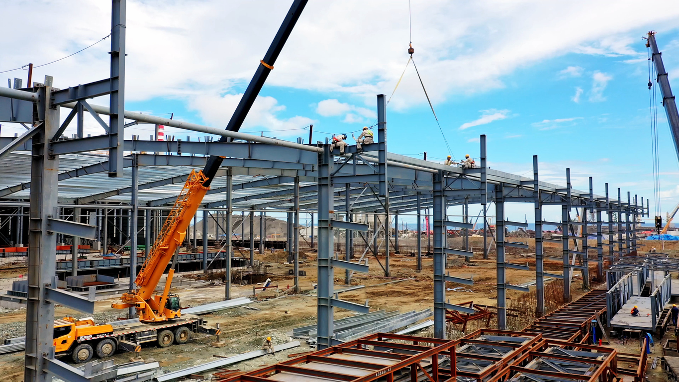 Contractors assembling a pre-engineered steel building at construction site