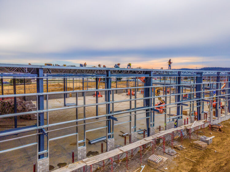 Construction workers assembling a pre-engineered steel building frame