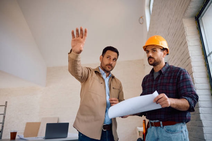 A homeowner discussing plans with a contractor regarding home addition