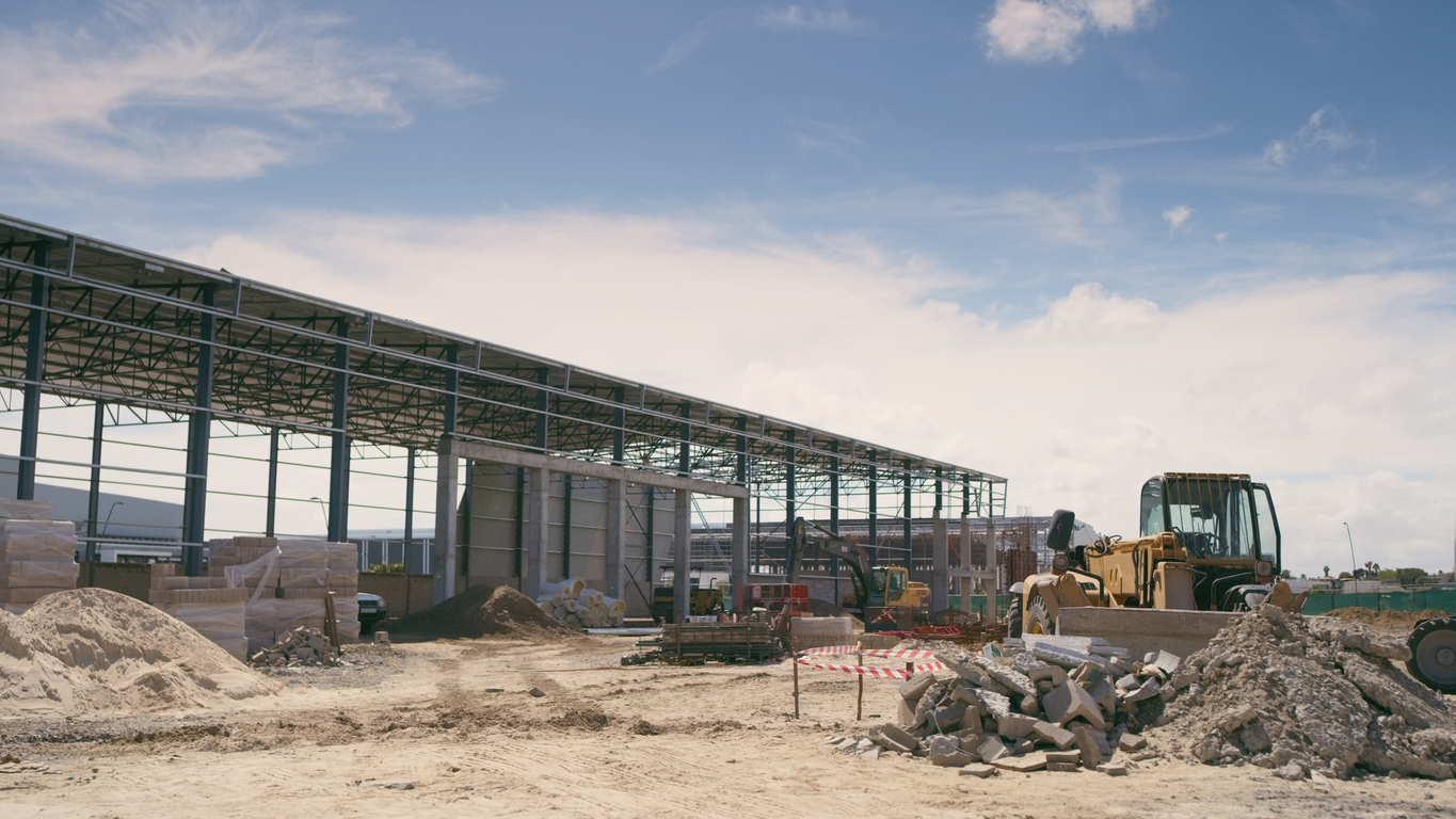Aviation hangar under construction with steel frame and grading