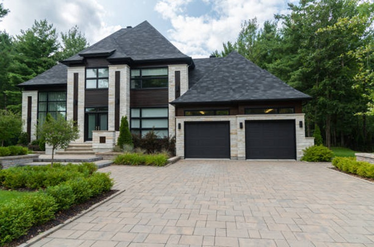 Modern custom home with large driveway and landscaped yard