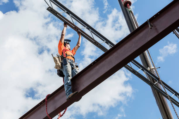 Worker installing steel beam on commercial construction site