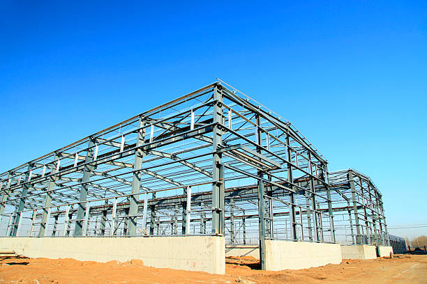 Steel building frame under construction with clear blue sky