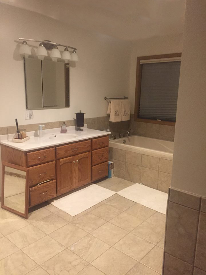 Spacious bathroom addition with tiled flooring and a bathtub installed