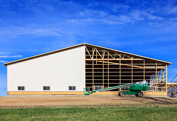 Partially built post frame pole barn with lift on construction site