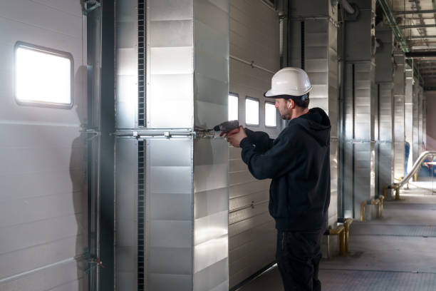 Contractor installing sectional hangar doors in facility