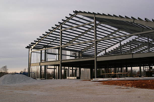 Steel frame structure under construction on gravel foundation site