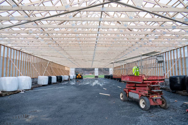 Cattle barn construction with framing and construction equipment