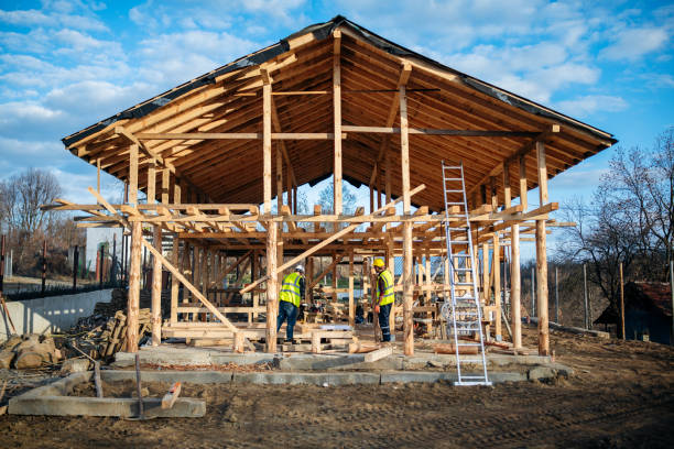 Workers constructing a wooden frame for a horse barn structure