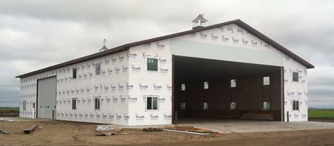 Newly completed horse barn with exterior sheathing and open space