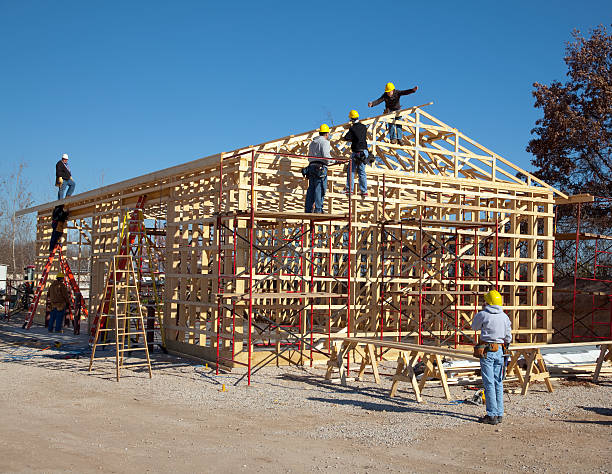 Contractors assembling timber frame for pole barn construction