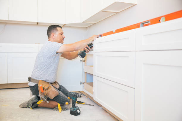 Contractor installing new kitchen cabinets during remodeling project