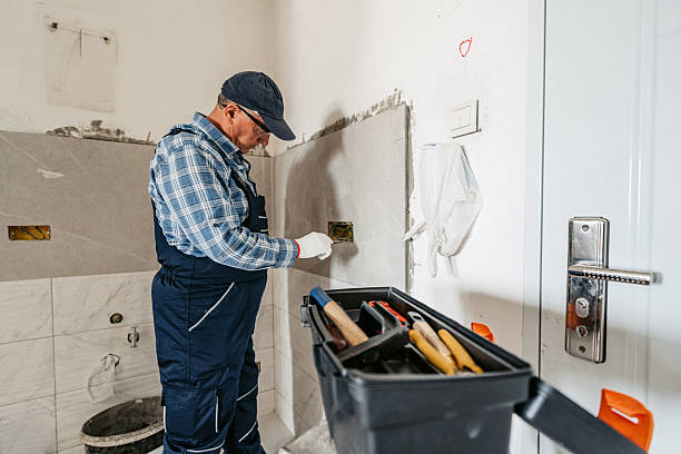 Contractor installs tile and wiring during bathroom addition project