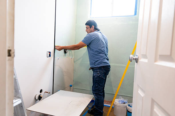 Contractor installing plumbing and panels for new bathroom addition