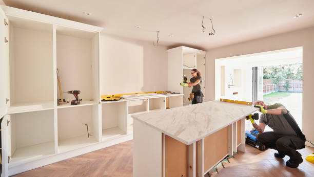 Contractors installing marble-look island countertop in new kitchen
