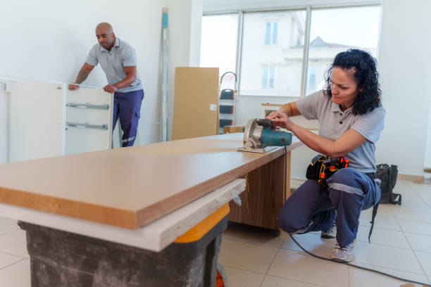 Worker cutting a countertop board during installation preparation