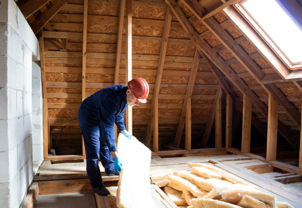 Installer placing insulation in attic as part of conversion project