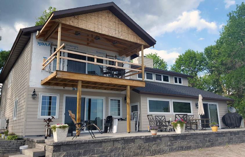 Home addition in progress with deck and upper level framing underway