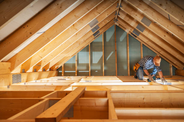 Worker installing beams in an attic for a conversion project