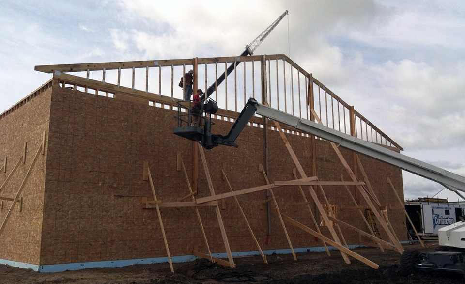 Hay Barn Construction in progress with builders setting trusses