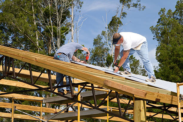Construction workers building a post frame pole barn roof
