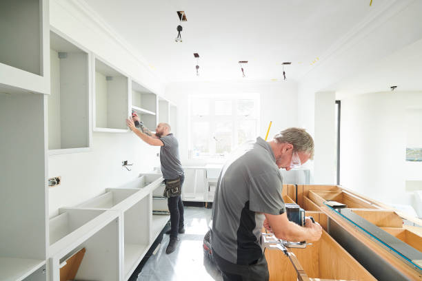 Contractors installing custom kitchen cabinetry during a home remodel