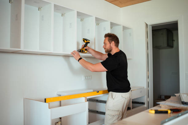 Cabinet installer carefully installing kitchen cabinets for perfect fit