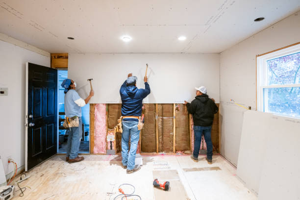 Contractors installing drywall panels during a home remodeling project