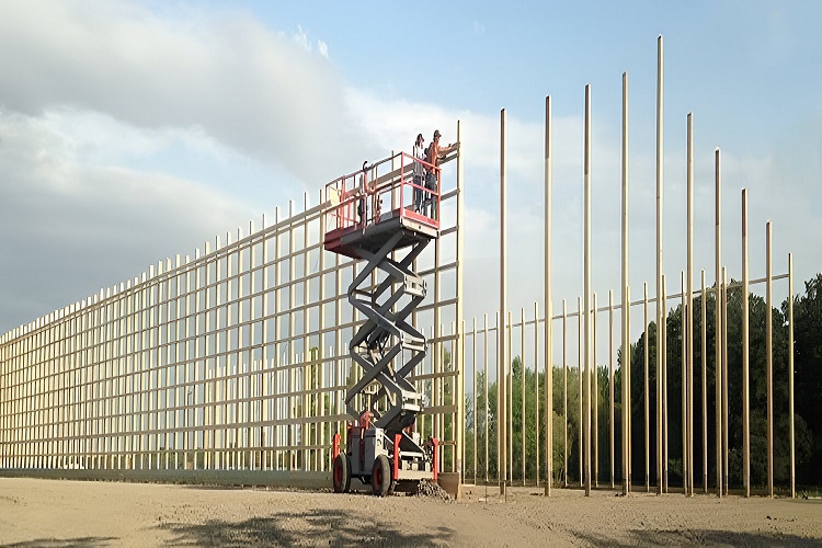 Workers on lift installing posts for a large pole barn structure
