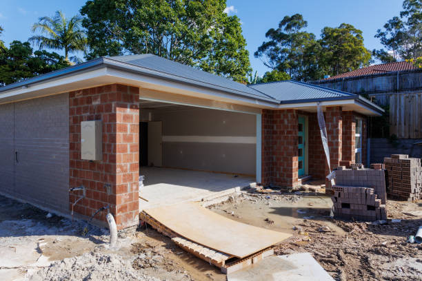 Garage addition construction in progress with brick walls and open bays